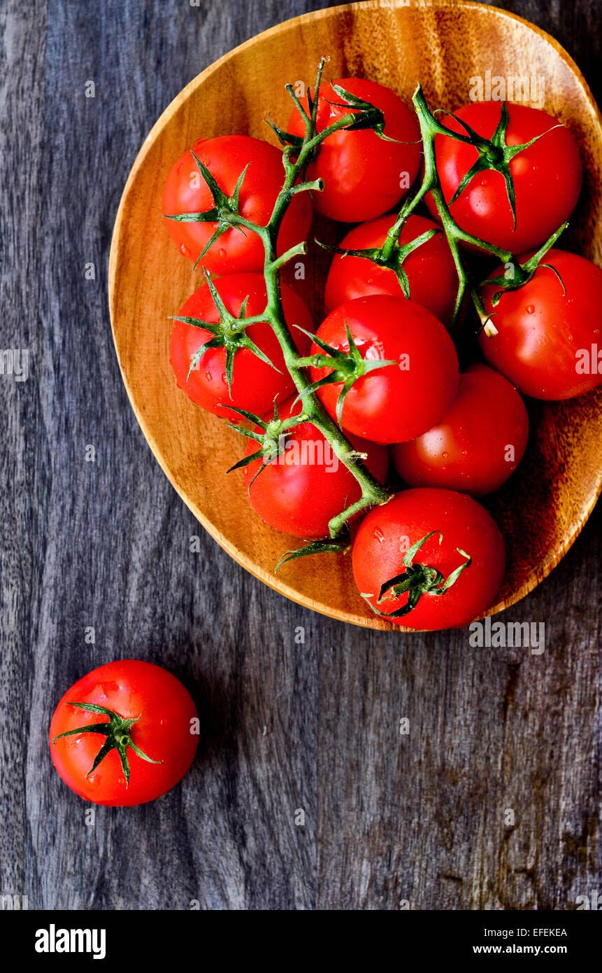 I pomodori su una placca in legno Foto Stock