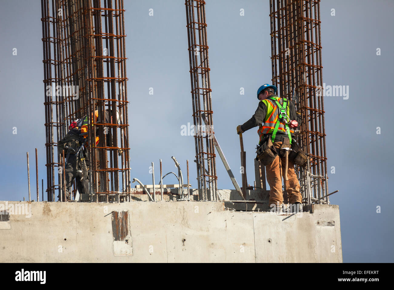 Due lavoratori edili lavorando sul tondino e fondamenta in calcestruzzo per la costruzione-Victoria, British Columbia, Canada. Foto Stock