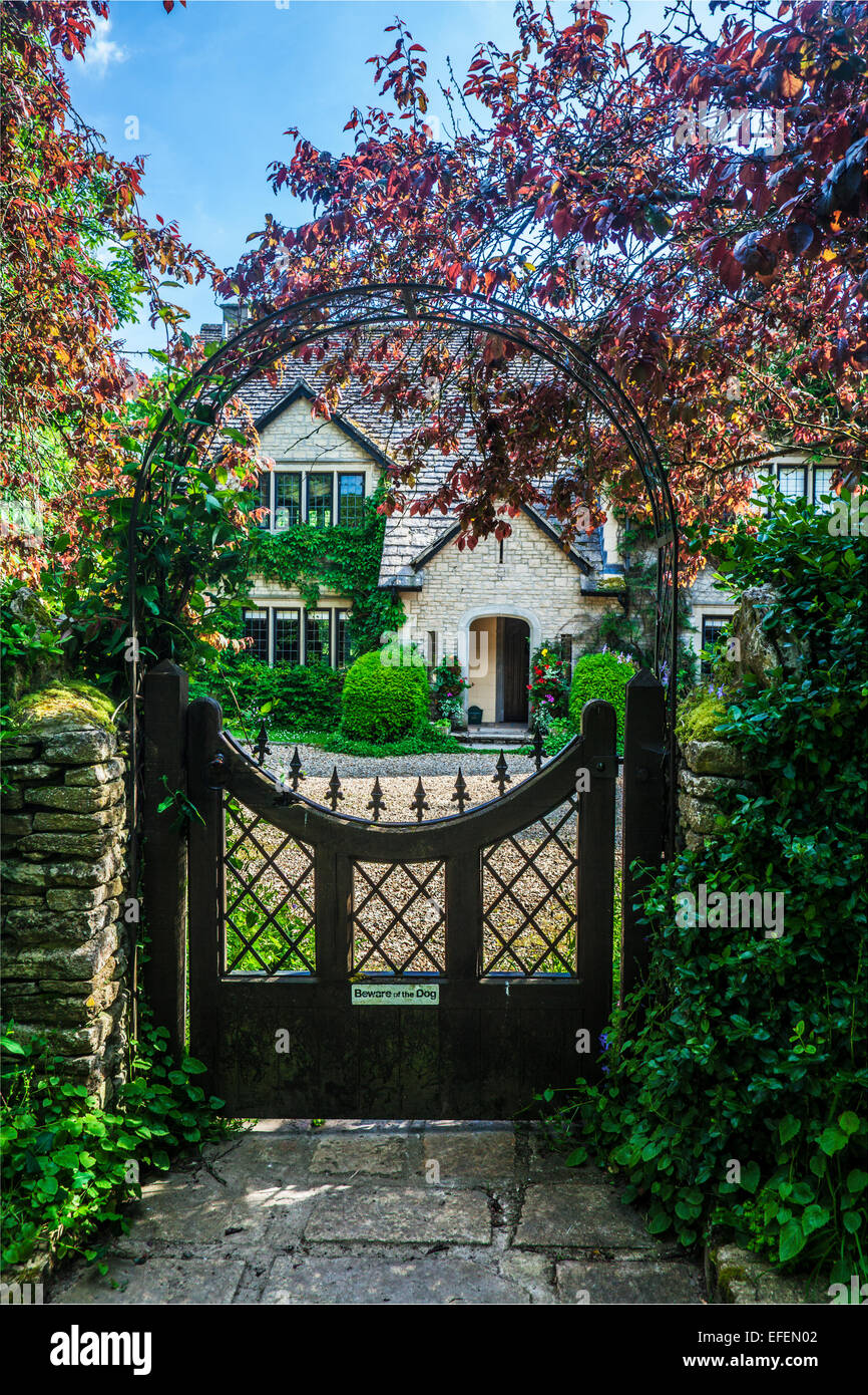 Vista attraverso il cancello del giardino di una casa di campagna in Cotswolds nel Wiltshire. Foto Stock