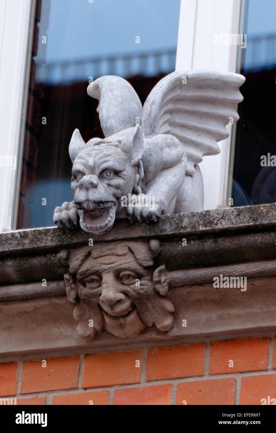 Gargoyle alato e ridere volto scolpito su un davanzale Arlen Germania Foto Stock