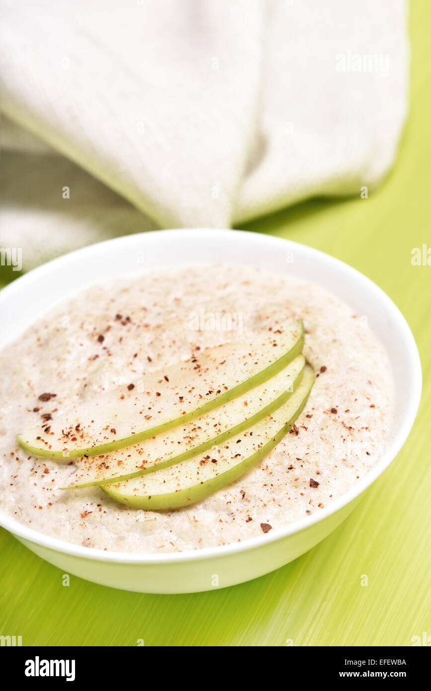 Porridge di fiocchi d'avena con mele e cannella in ciotola bianco Foto Stock