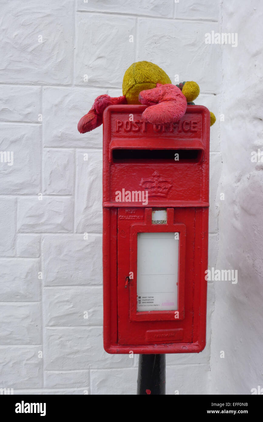 Un letter box sulla parete dipinta di bianco di 'The Boathouse' sull'Isola di Ulva con un giocattolo aragosta sulla parte superiore Foto Stock