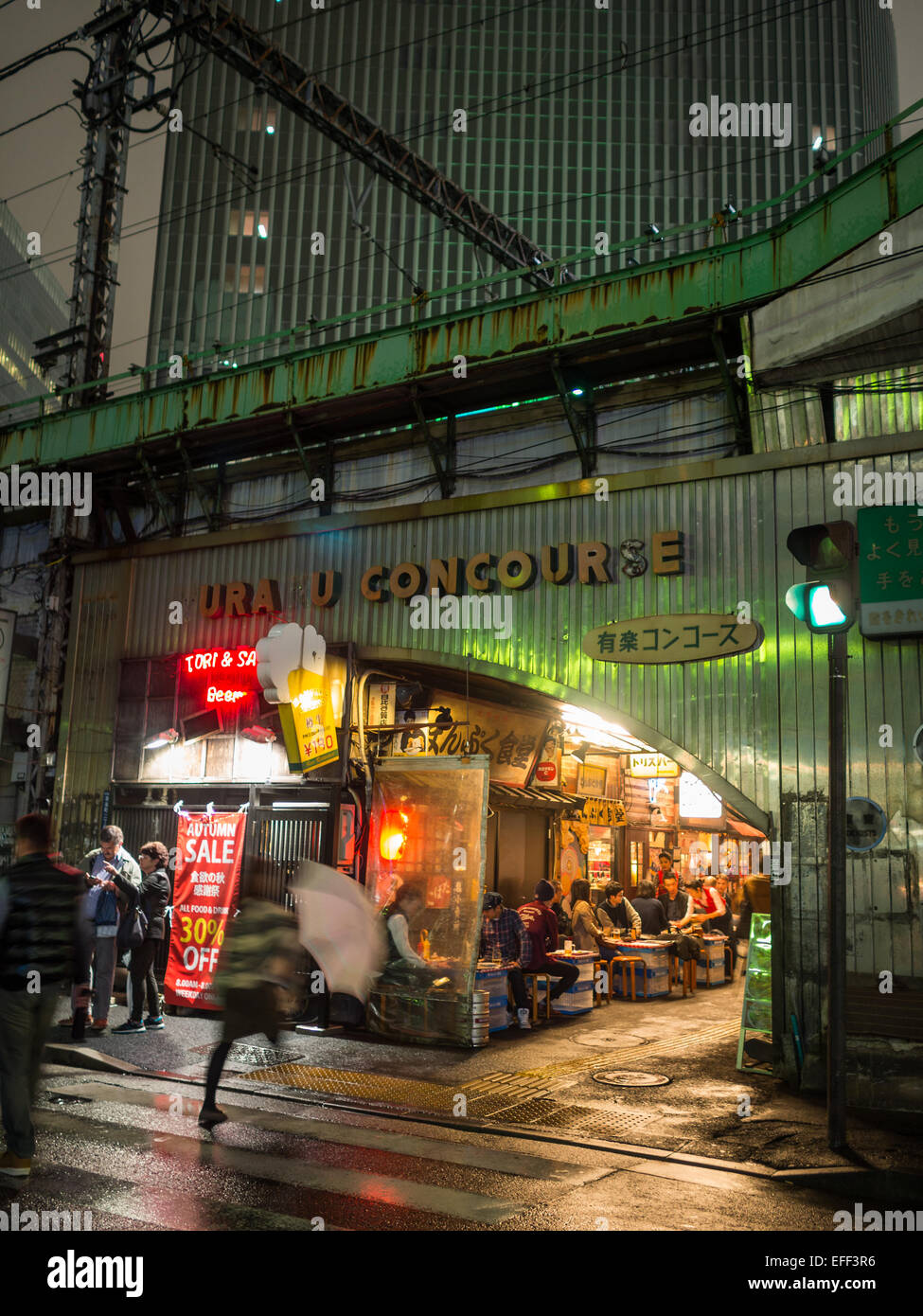 Persone mangiare nei tradizionali ristoranti di Tokyo sotto la linea ferroviaria Foto Stock