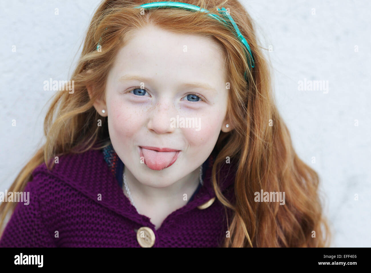 Ragazza con i capelli rossi spuntavano lingua. Foto Stock