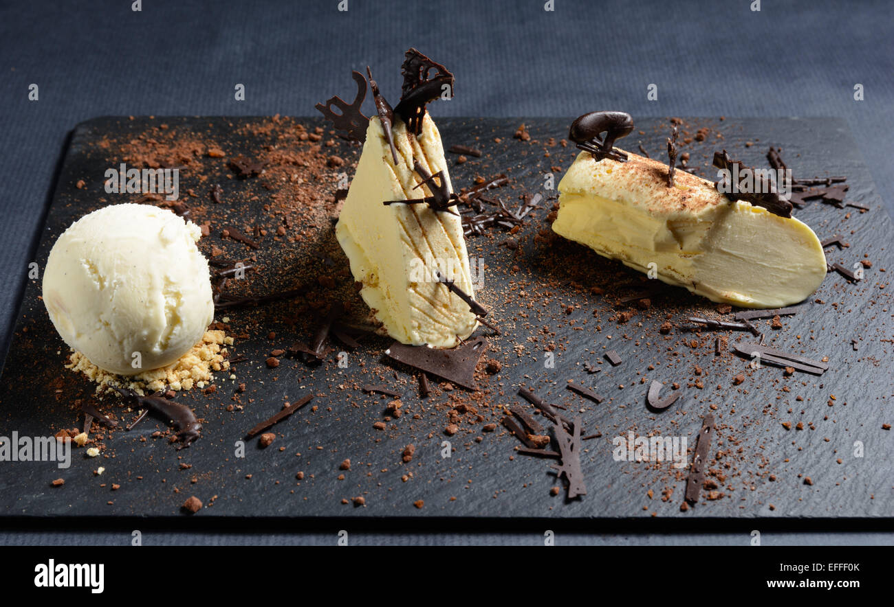 Il cioccolato bianco e vaniglia parfait di cioccolato crumble su un nero ardesia piastra Foto Stock