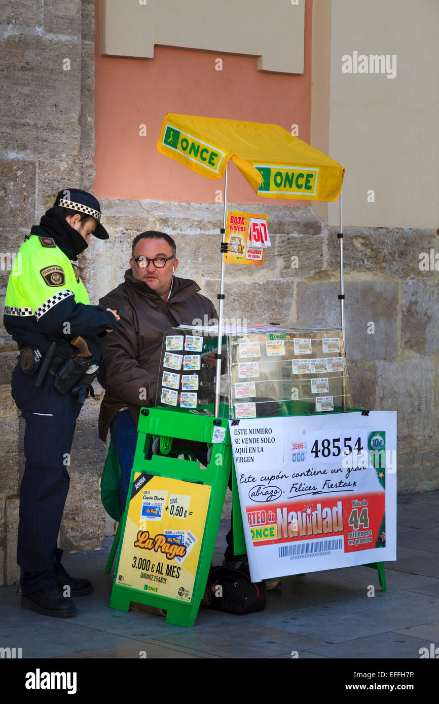Un policia ufficiale di polizia parla di una lotteria venditore Foto Stock