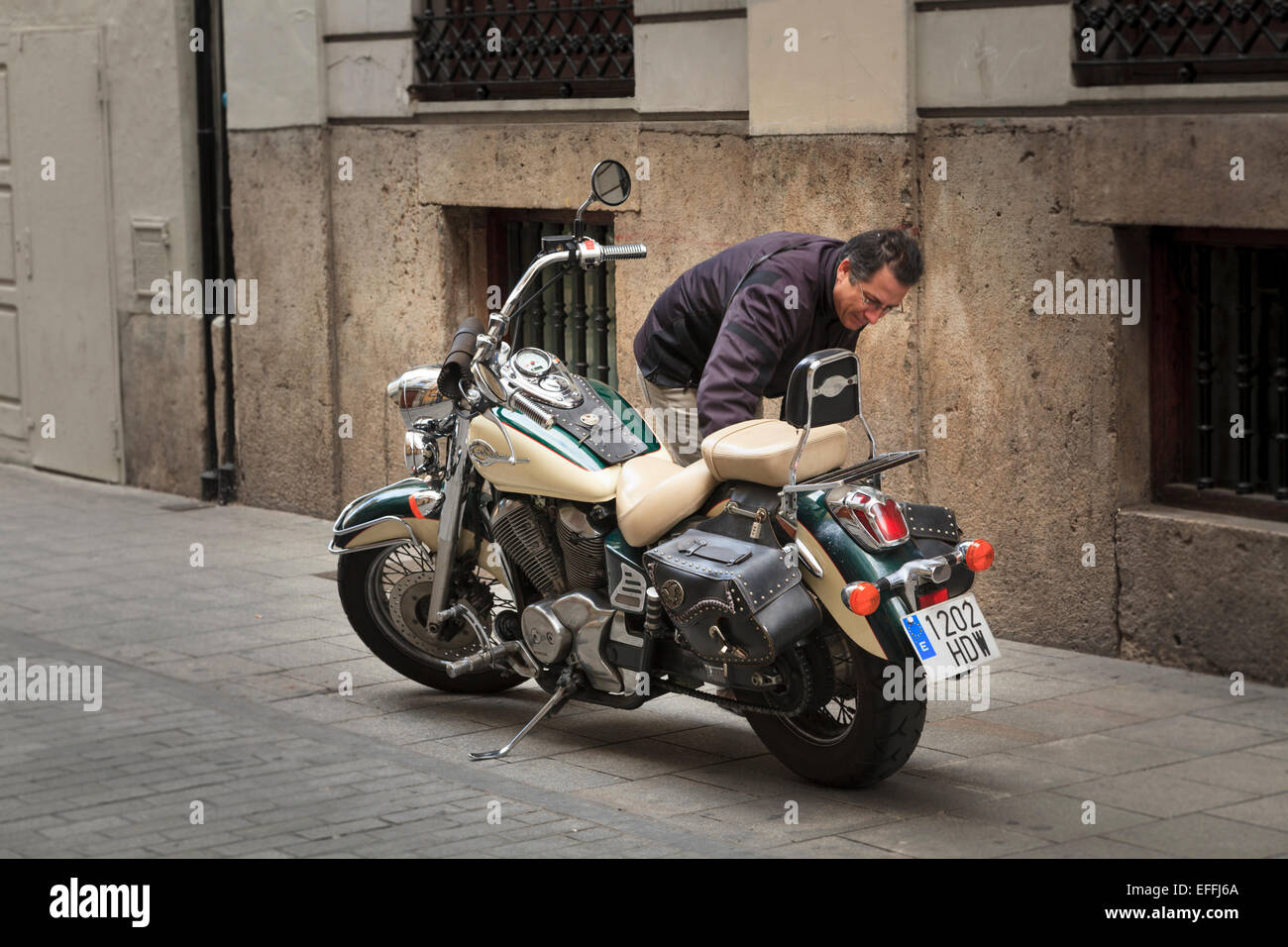 Uomo che pulisce la sua Honda Shadow V twin cruiser motociclo di tipo Foto Stock