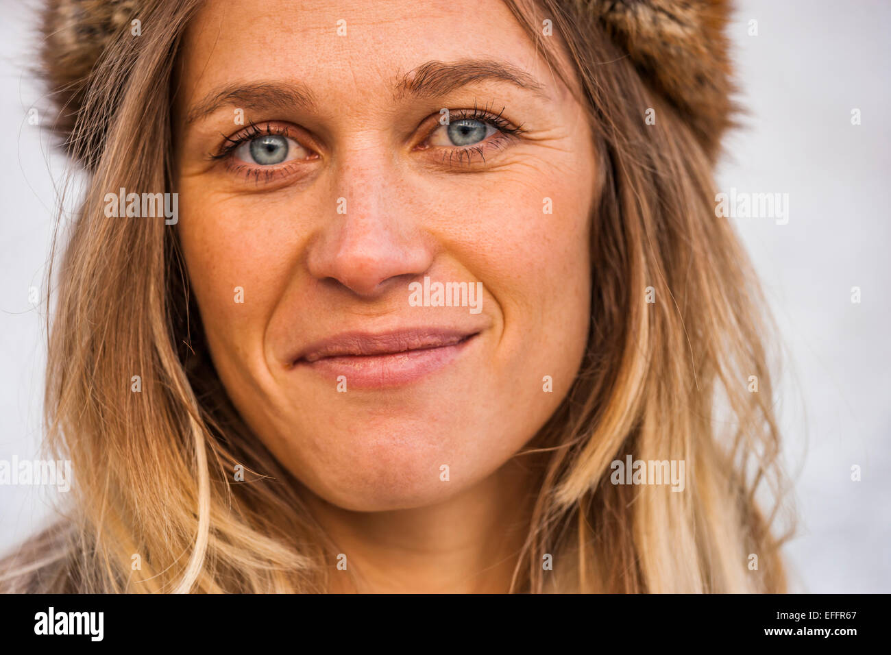 Ritratto di sorridente bionda che indossa il cappuccio di pelliccia Foto Stock