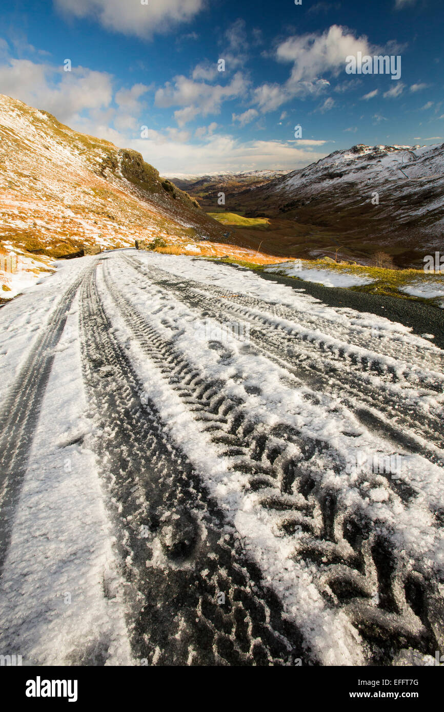 Tracce di pneumatici su Wrynose Pass in inverno, Lake District, UK. Foto Stock