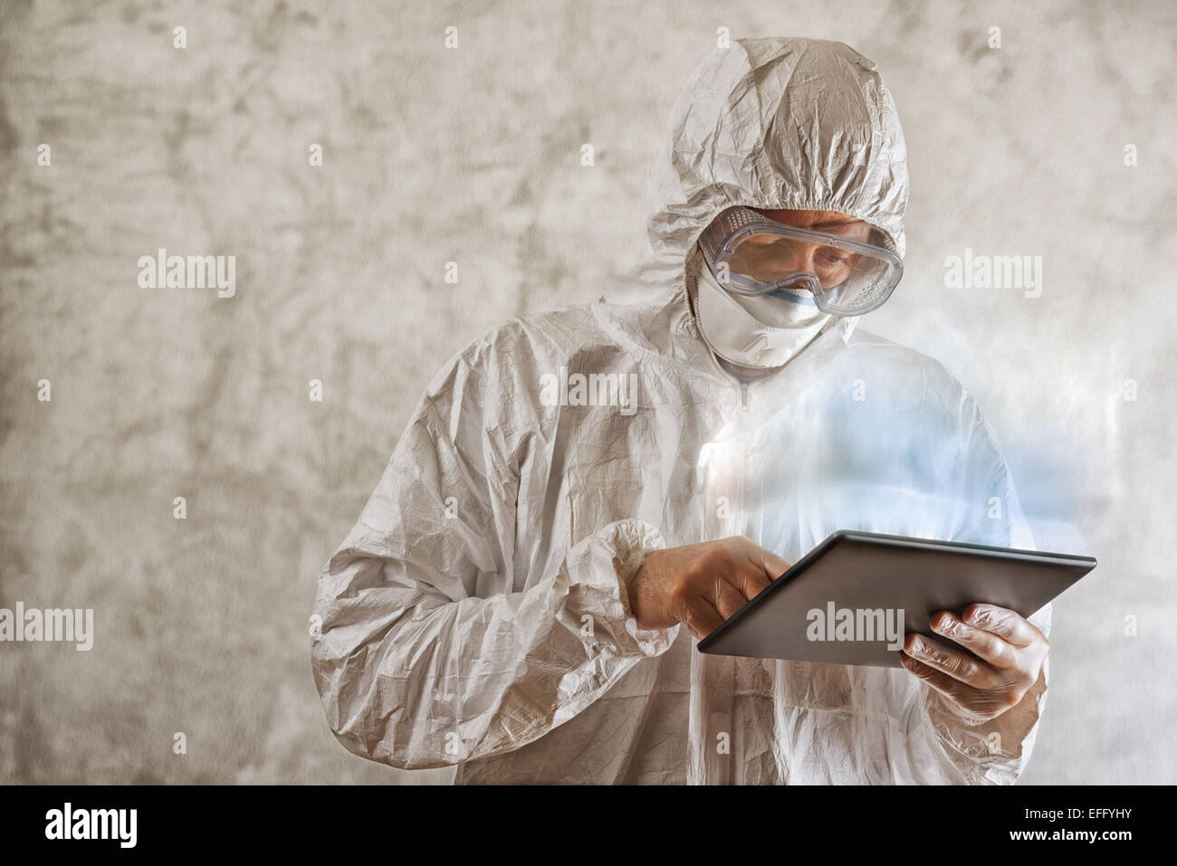 Scienziato di chimica in laboratorio protettivo Abbigliamento tramite Digital Computer tablet Foto Stock