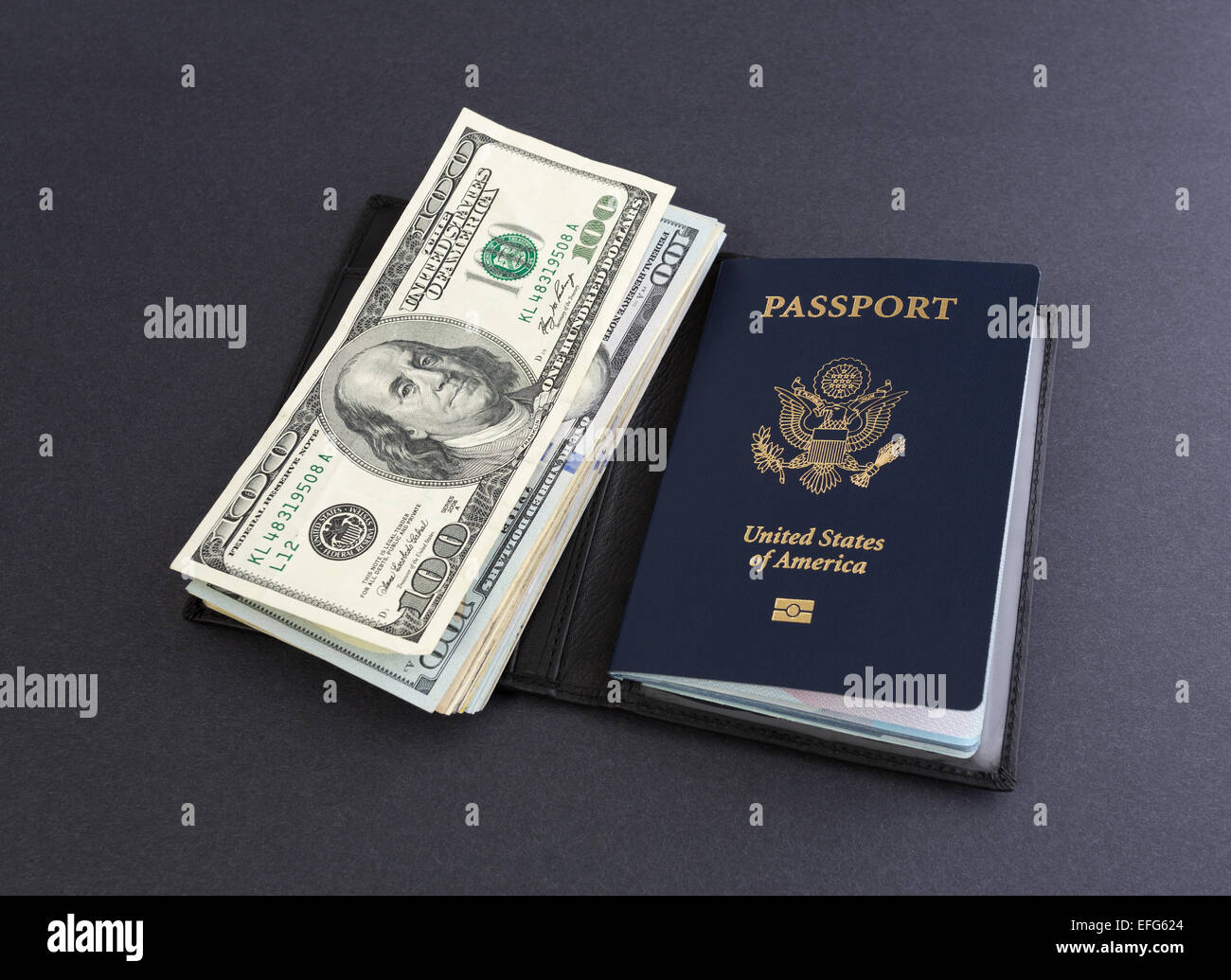 Gli Stati Uniti d'America il passaporto in un supporto in pelle con diverse centinaia di fatture del dollaro sulla cima di uno sfondo scuro. Foto Stock