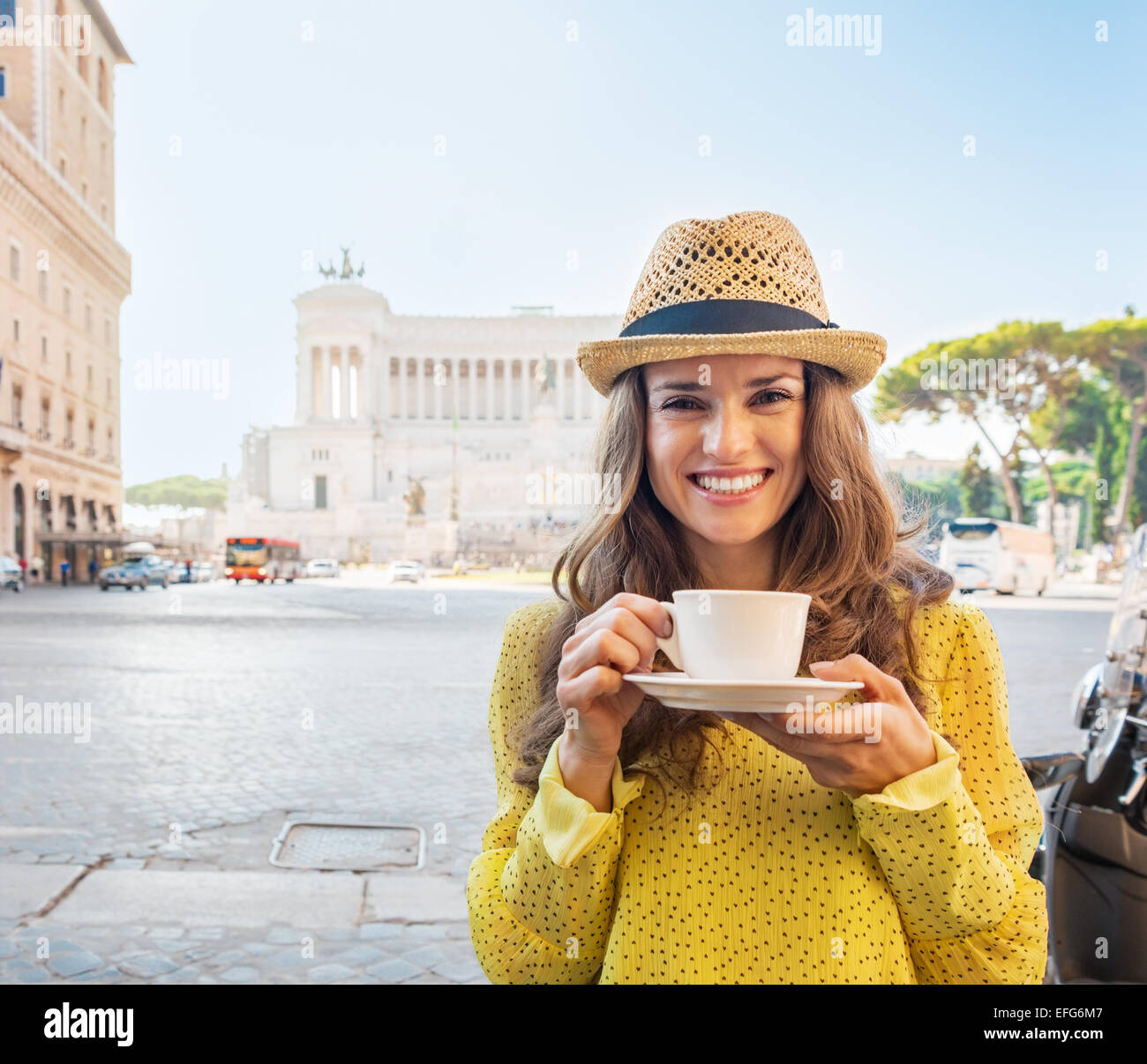 Ritratto di felice giovane donna con tazza di caffè sulla piazza Venezia a Roma, Italia Foto Stock