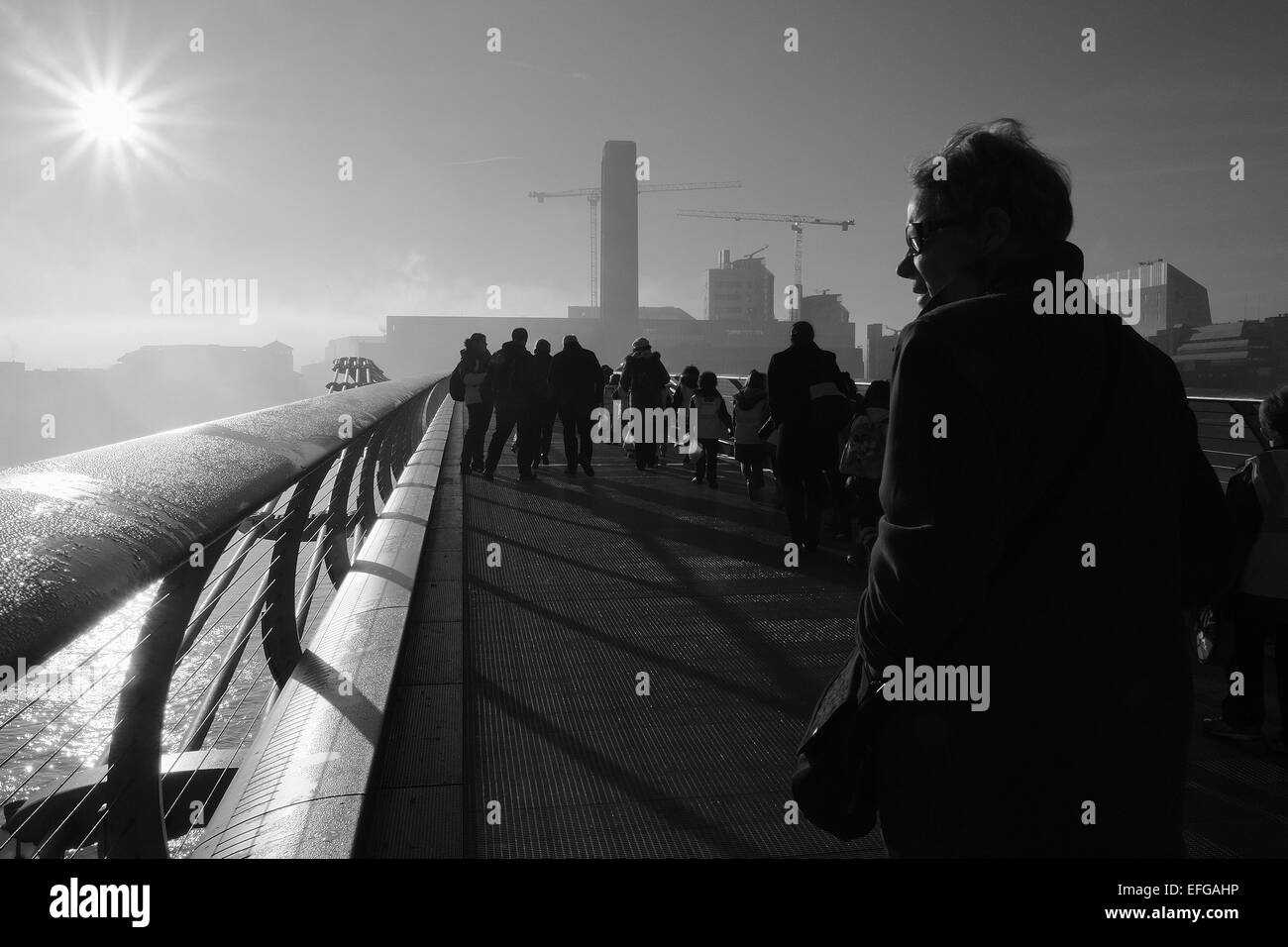 Pedoni sul Millennium Bridge di Londra a piedi verso la Tate Modern guardando oltre il Tamigi verso London Bridge. Foto Stock