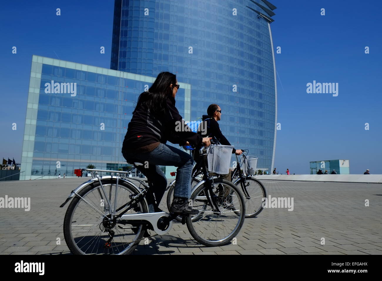 W Barcelona hotel con due ciclisti andando passato. Foto Stock
