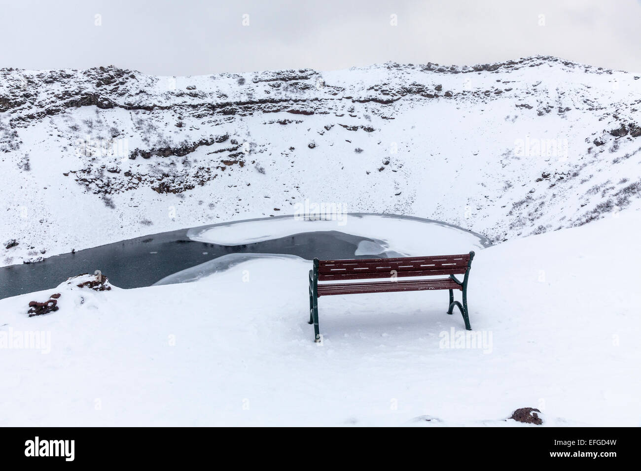 La caldera rocciose di Kerid (o) Kerith vulcano e congelato il cratere del lago in Islanda, una popolare destinazione turistica in inverno durante una nevicata Foto Stock