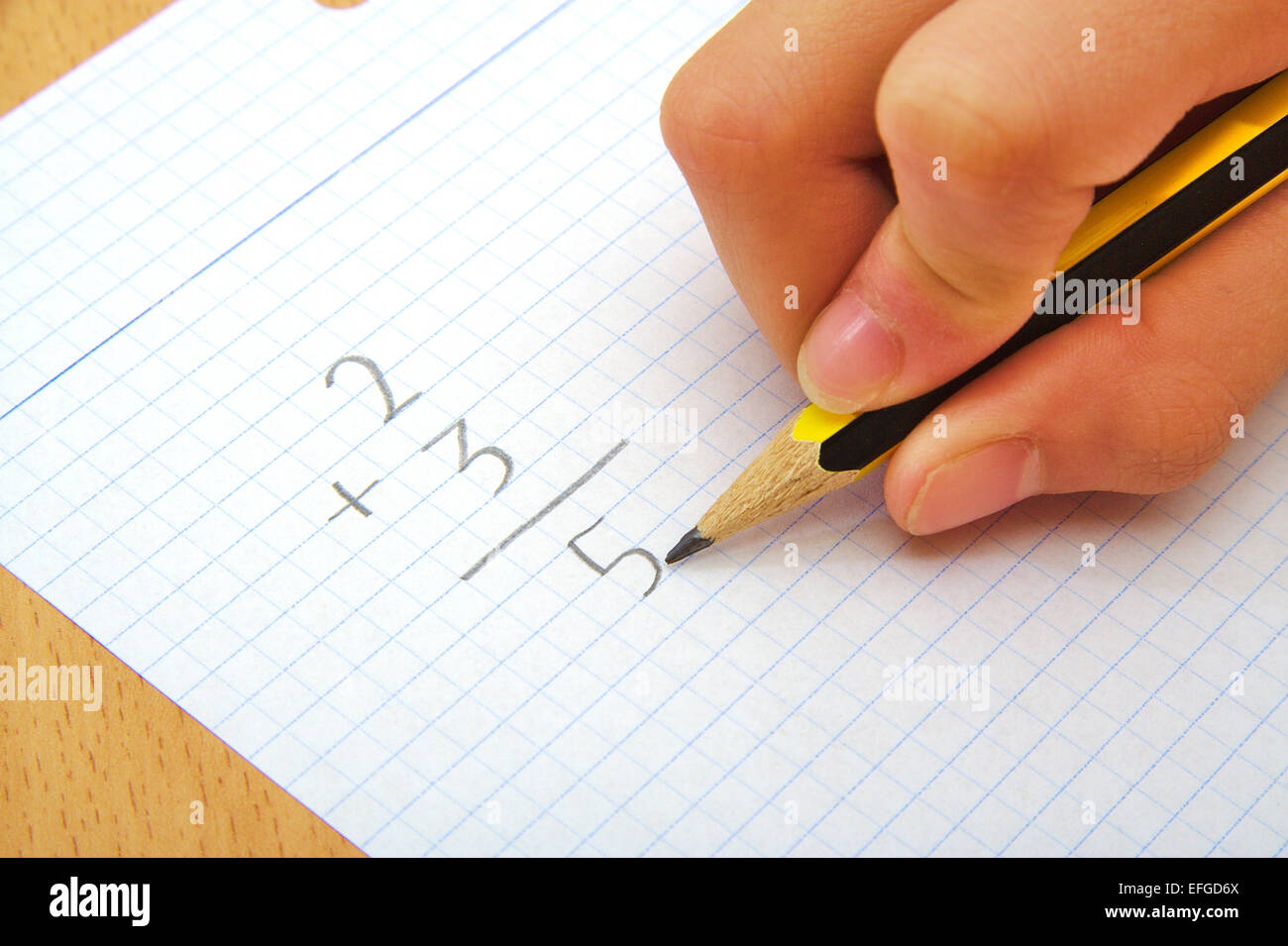 La mano di un bambino facendo una somma. Matematica. Il concetto di scuola Foto Stock