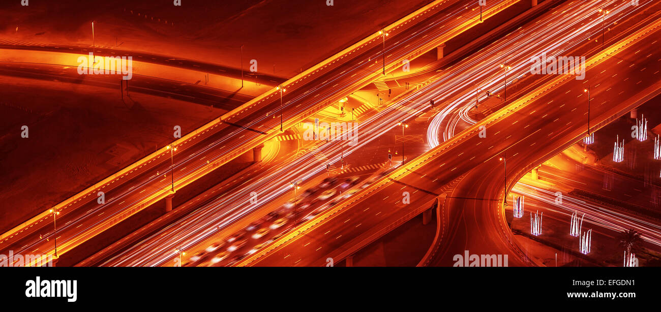 Notte strade sfondo panoramico, bird eye view su autostrada illuminato, moderna autostrada nella città di Dubai, UAE Foto Stock