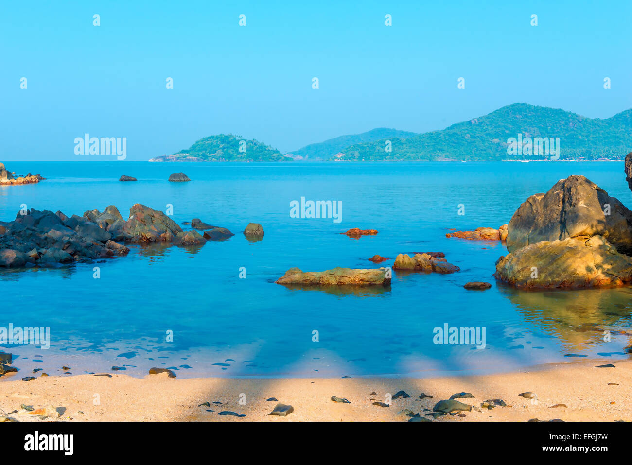 Montagne verdi all'orizzonte e la laguna blu Foto Stock