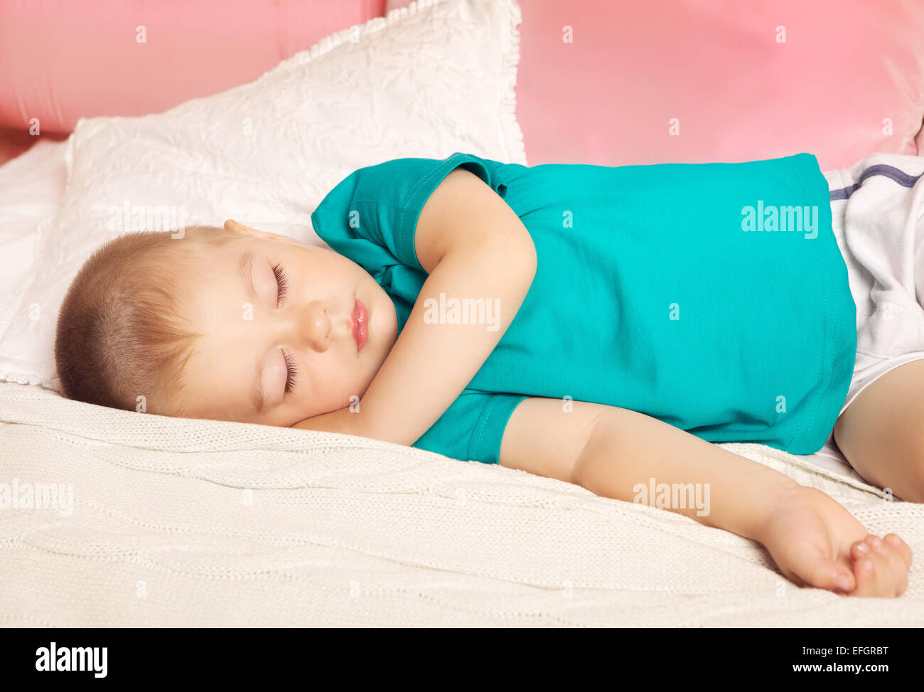 Carino il bambino dorme sul letto di casa Foto Stock