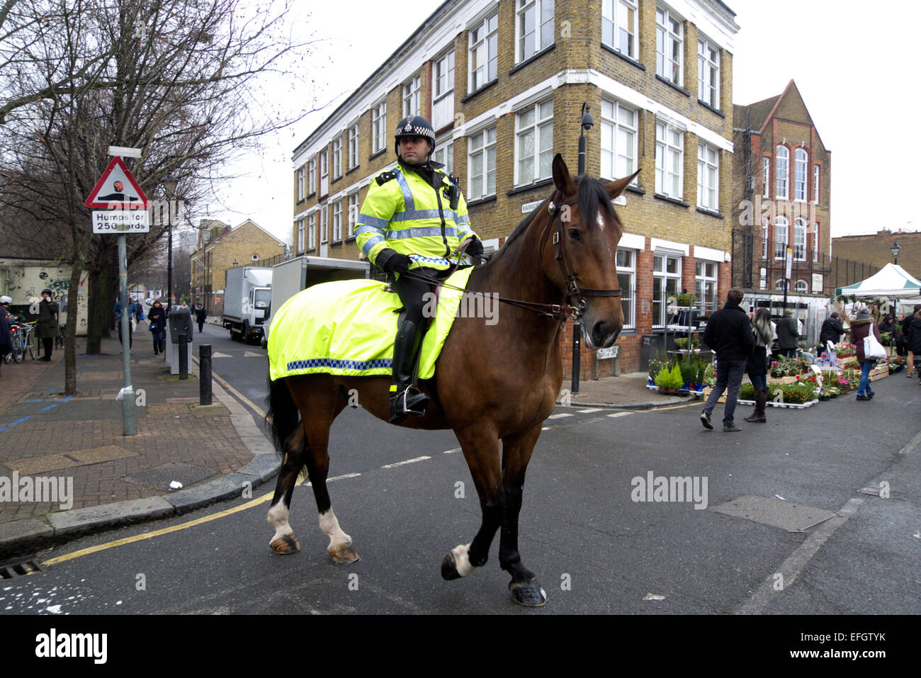 Regno Unito Londra est columbia road domenica il mercato dei fiori è montato un funzionario di polizia Foto Stock