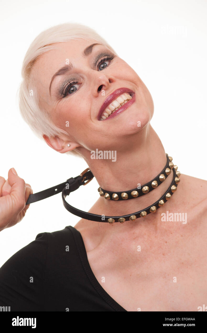 Donna matura con corti capelli biondi tirando collana Foto Stock