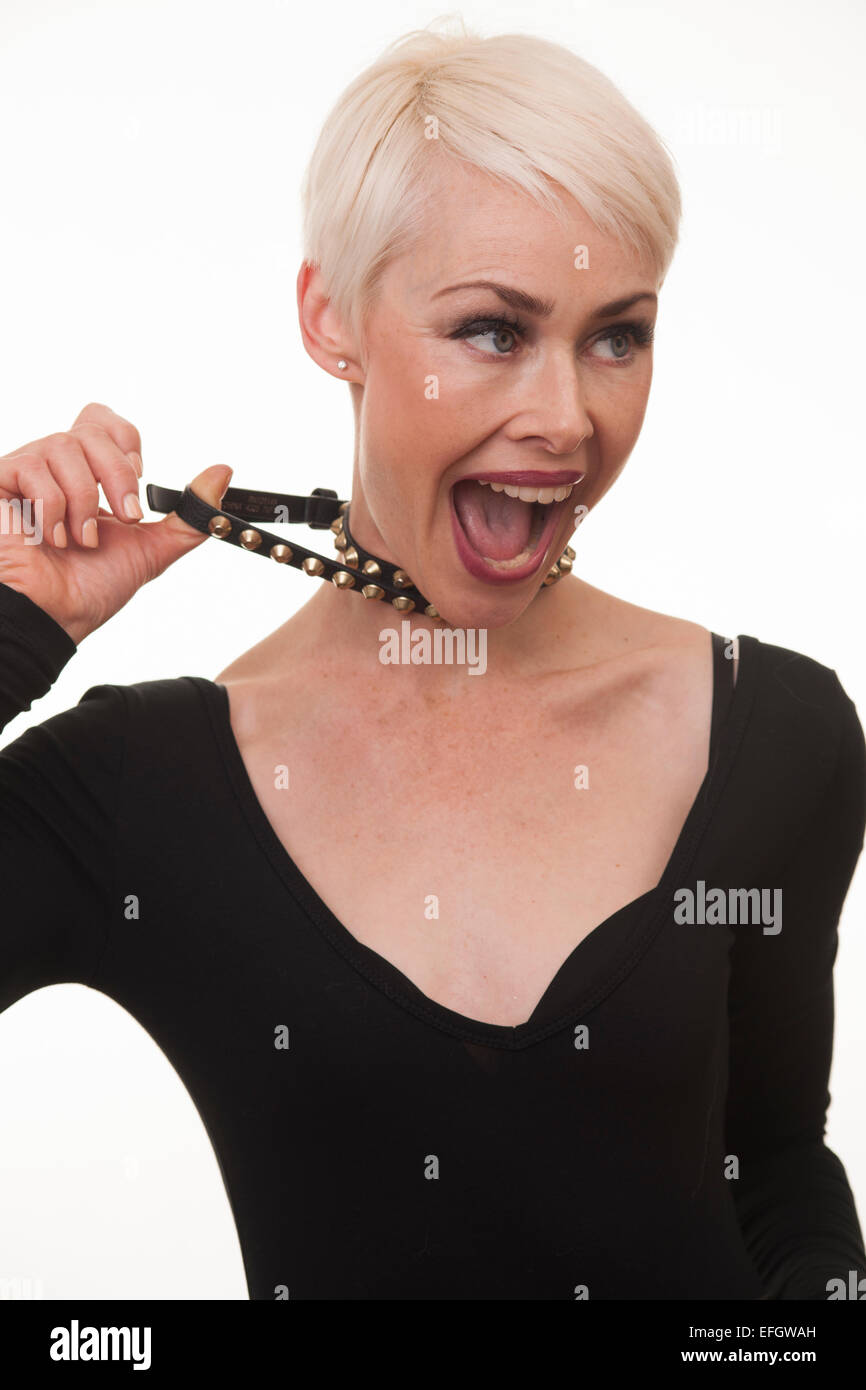 Donna matura con corti capelli biondi tirando collana Foto Stock