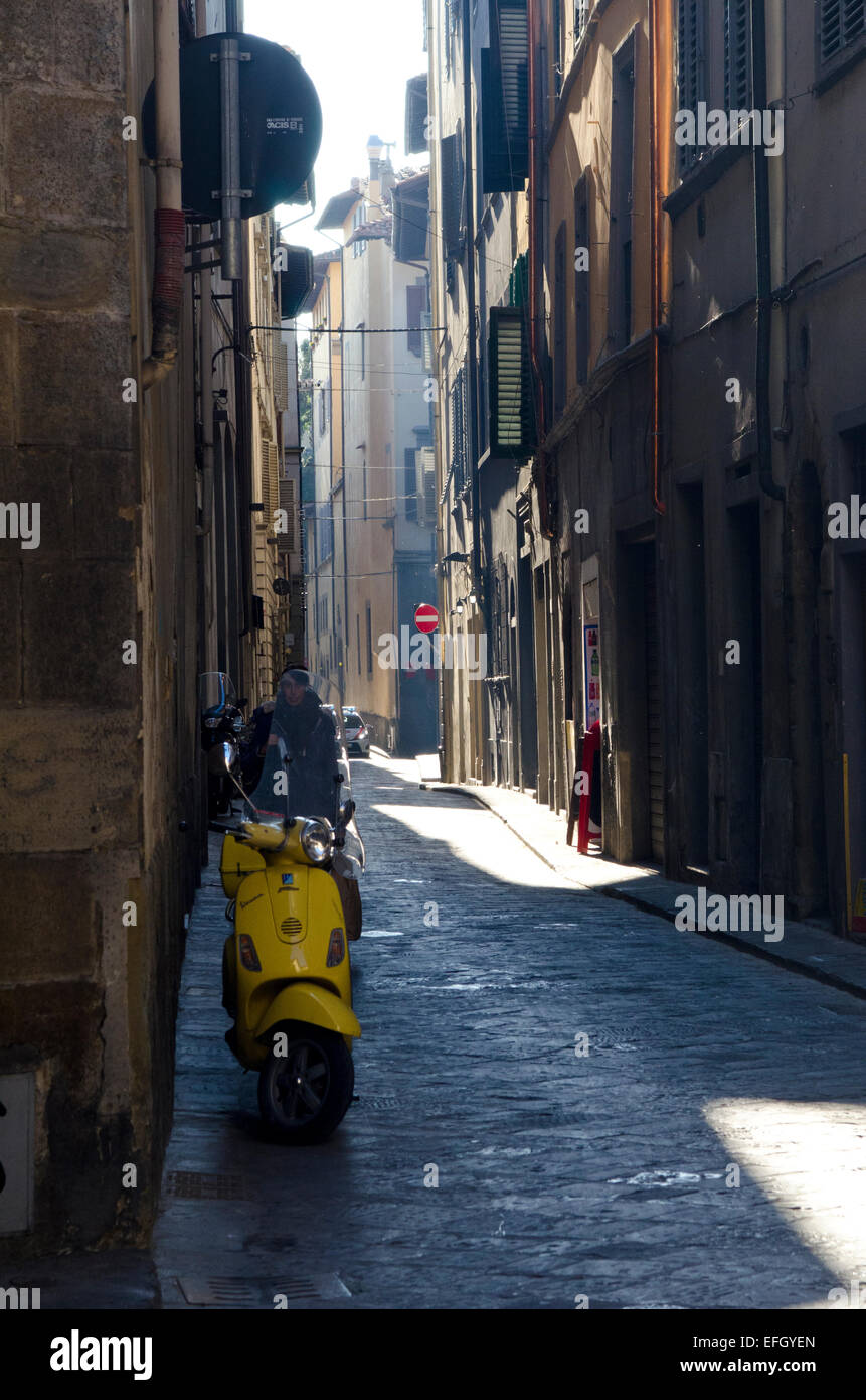 Restringere backstreet in Firenze, Italia, mostrando scooter giallo Foto Stock