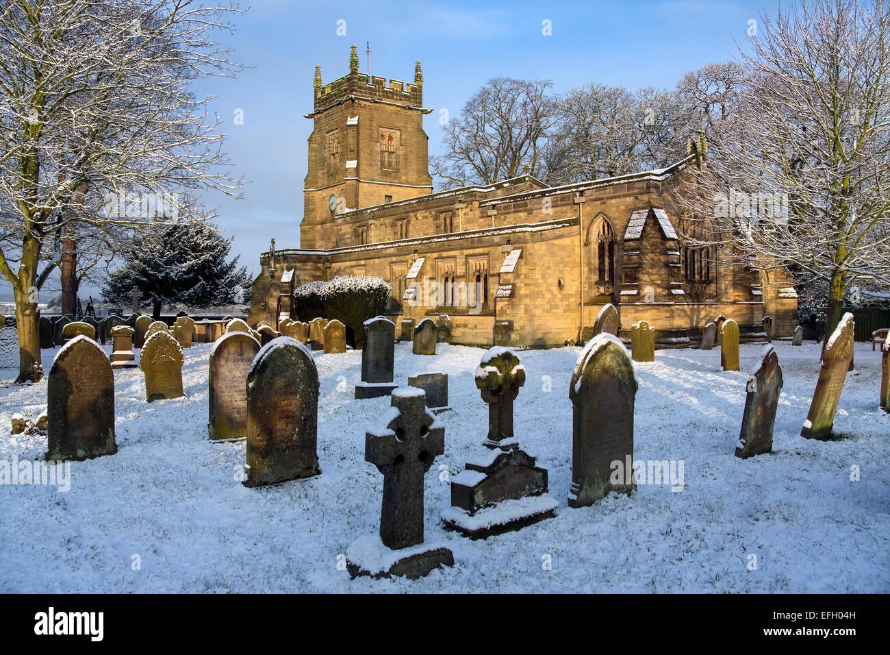 In inverno la neve nel cimitero di un inglese chiesa parrocchiale nel piccolo villaggio di Slingsby nel North Yorkshire in Inghilterra settentrionale Foto Stock