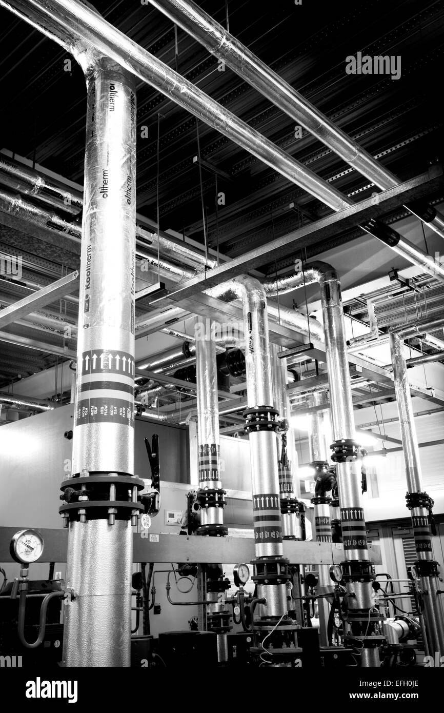 Caldaia a biomassa e piping industriale in un impianto di biomasse, in bianco e nero Foto Stock