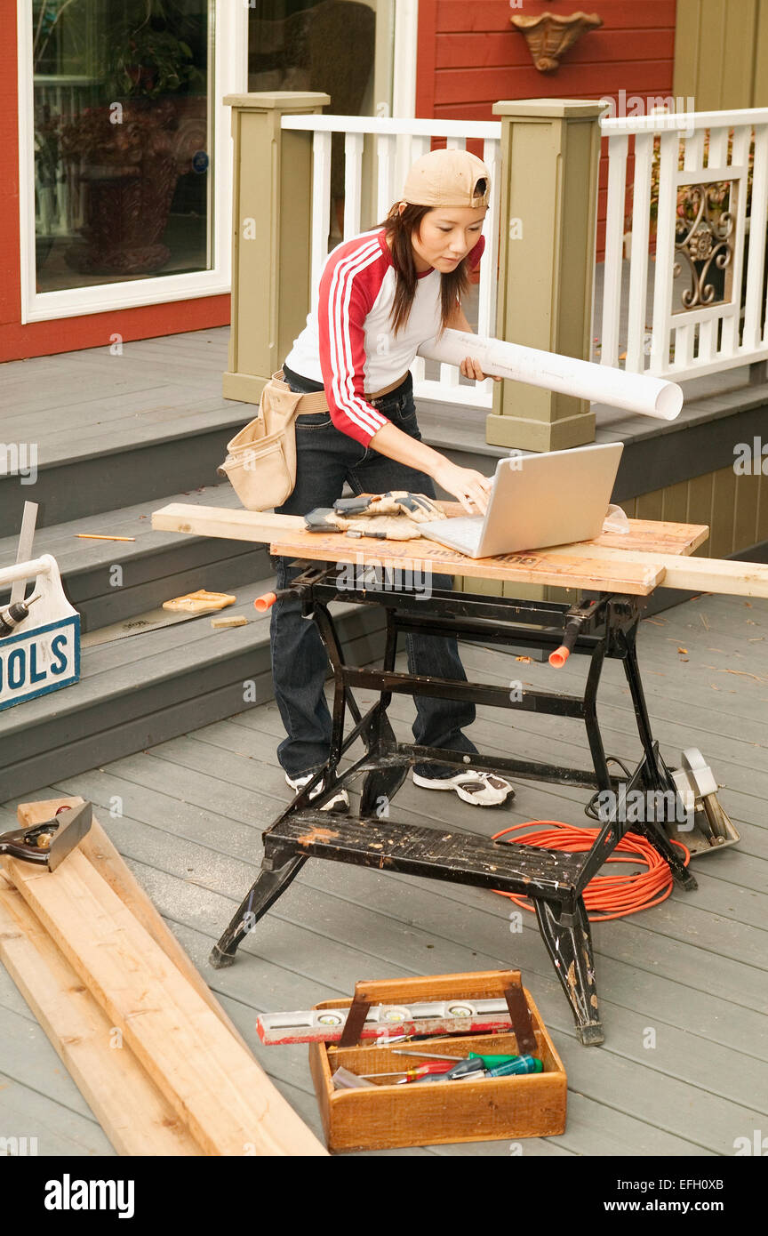 Asian femmina casa facendo lavori di rinnovo Foto Stock