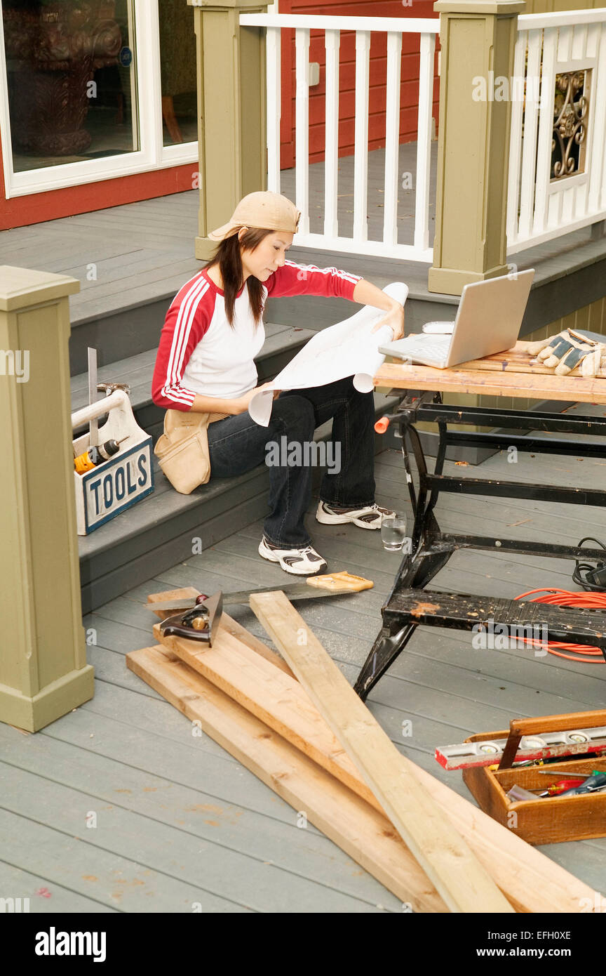 Asian femmina casa facendo lavori di rinnovo Foto Stock