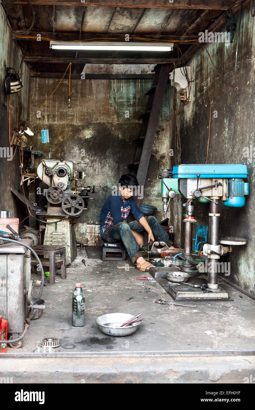 Il vietnamita meccanico che lavora nella sua officina a Can Tho. Foto Stock