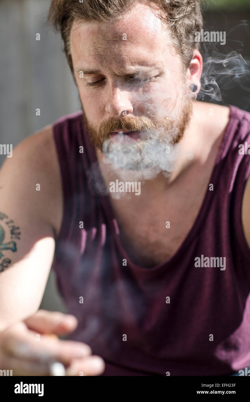 Close up di uomo che fuma sulla scala Foto Stock