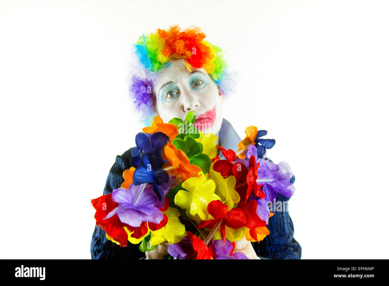 Donna vestita di clown parrucca e make-up con una triste espressione in tono alto Foto Stock