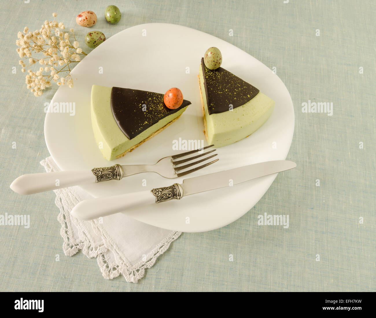 Torta di Pasqua con tè match decorate ganache al cioccolato e dolce-stuff uova. Vicino a tazza di caffè. A partire dalla serie elegante dessert Foto Stock