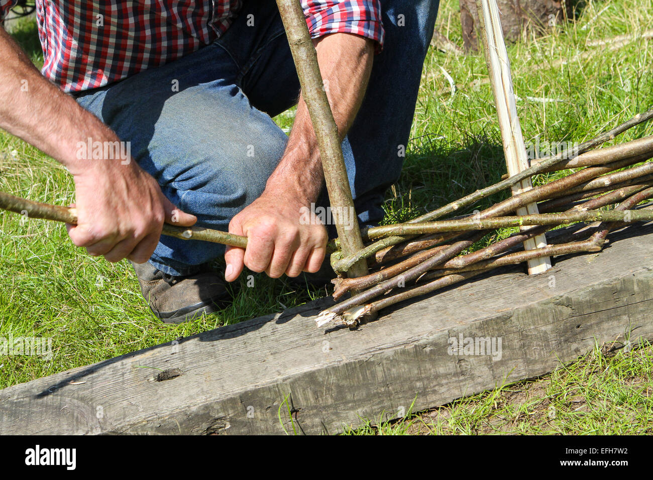 Artigiano dimostrando willow recinzione a tessitura spettacolo agricolo, close up Foto Stock
