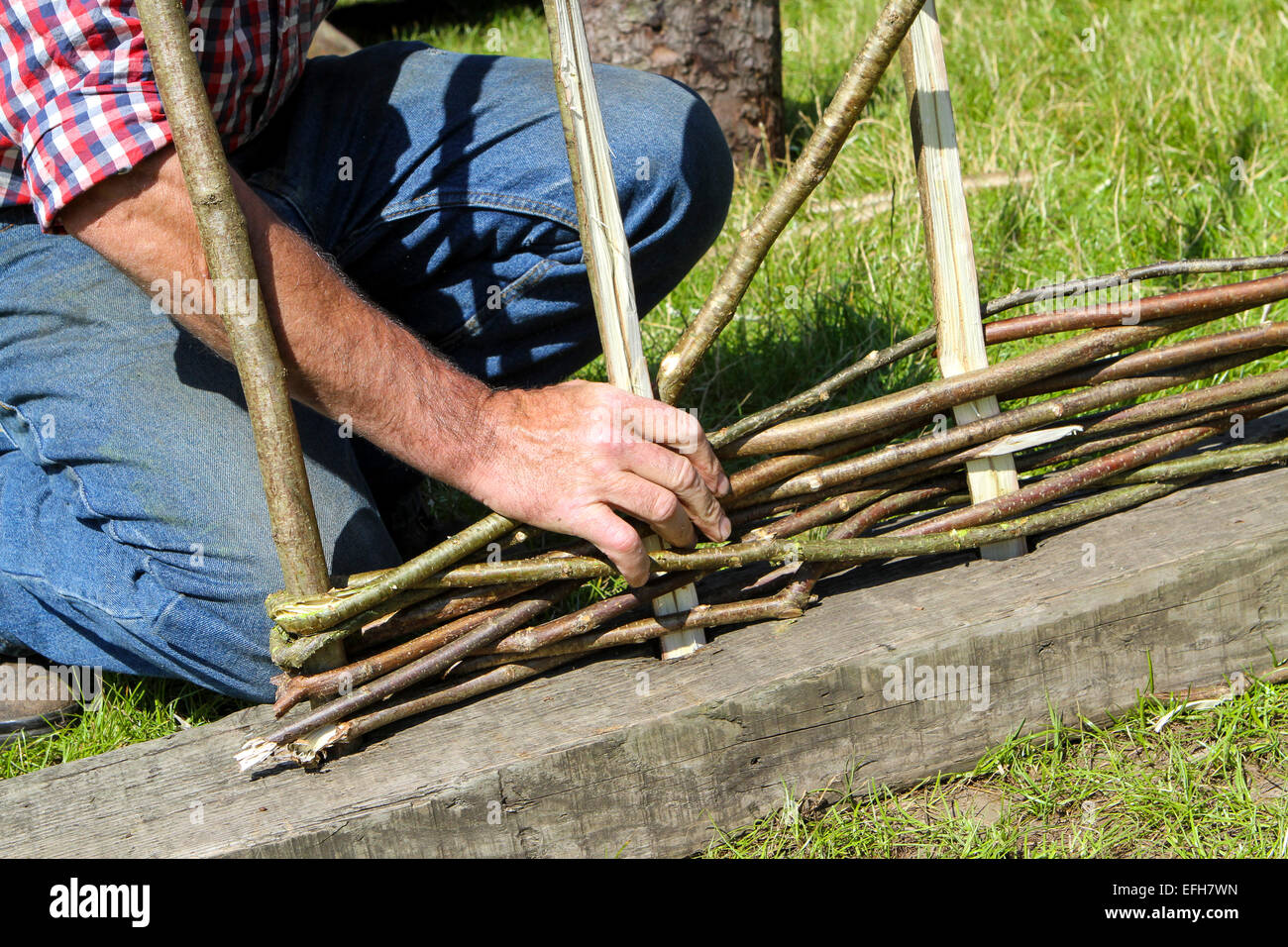 Artigiano dimostrando willow recinzione a tessitura spettacolo agricolo, close up Foto Stock