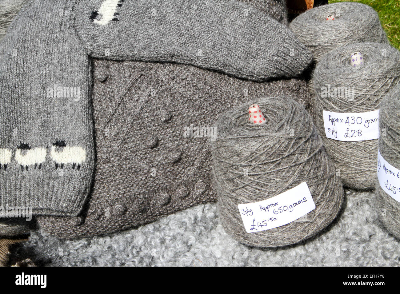 Grigio di lana di pecora bobine di filato e maglieria su agricolo mostra mercato in stallo Foto Stock