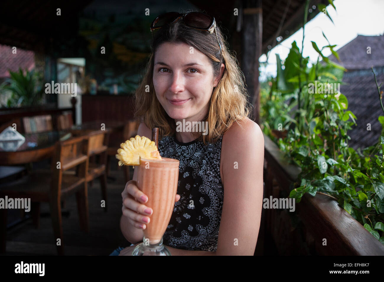 Una donna di bere un frullato di frutta in vacanza Foto Stock