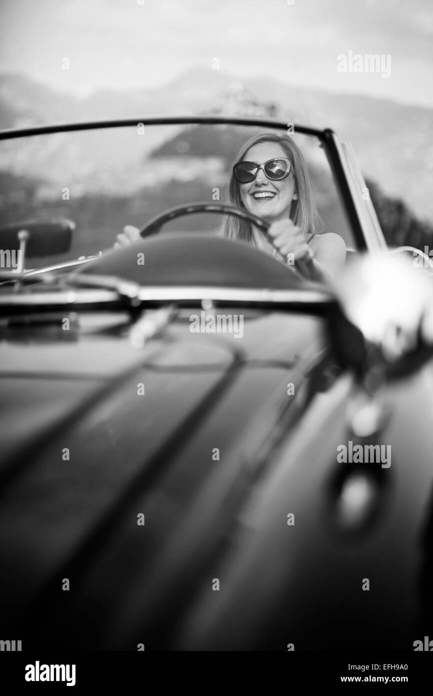 Giovane donna alla guida di un classico vintage auto sportiva nel sud della Francia Foto Stock