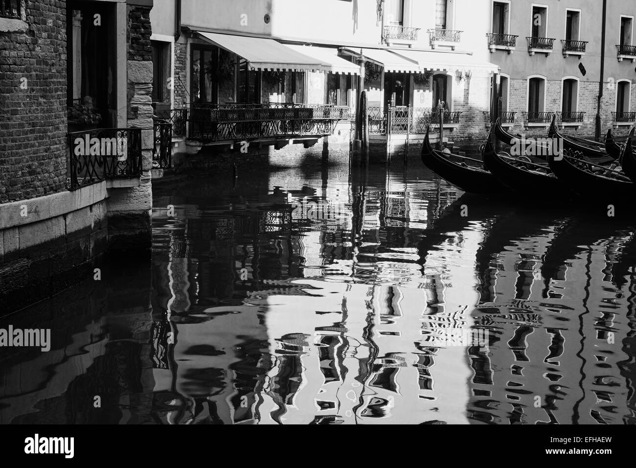 Tranquilla scena veneziana con riflessioni e gondole attraccate Venezia Veneto Italia Europa Foto Stock