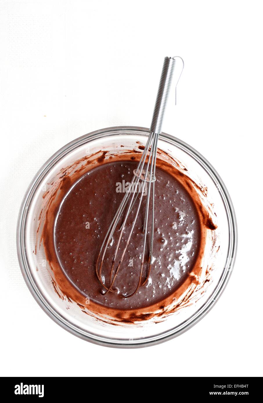 La miscelazione di un impasto di cioccolato in una ciotola di vetro per la realizzazione di una torta. Foto Stock