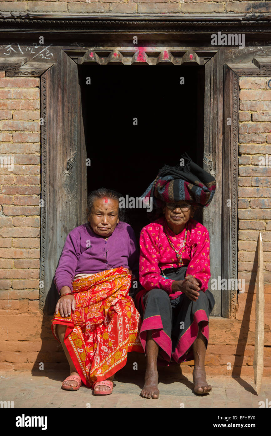 Il vecchio donna seduta in una porta al Potter's Square, Bhaktapur, Valle di Kathmandu, Nepal Foto Stock