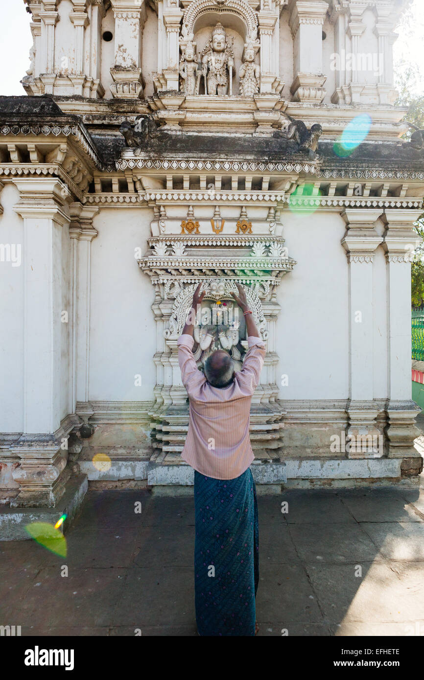 Indian uomo offre preghiere con le braccia sollevate a Devi Bagh tempio in Hyderabad, India Foto Stock