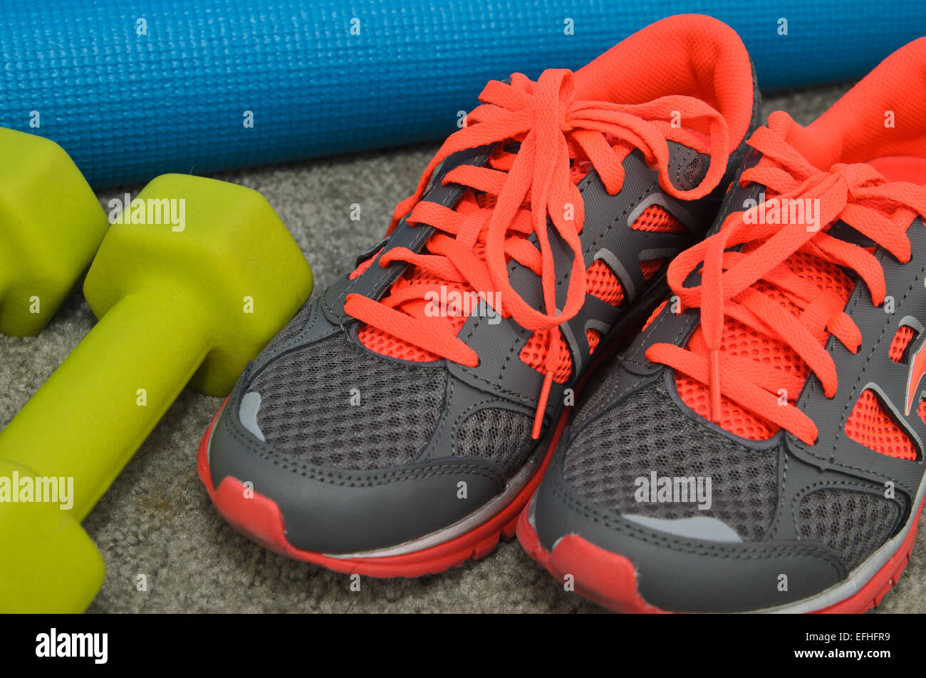 Luminose sport scarpe con il manubrio e materassino yoga Foto Stock