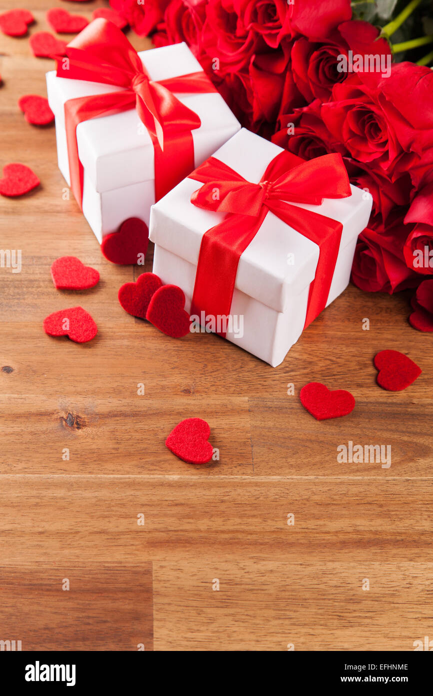 Concetto di San Valentino con bouquet di rose e dono avvolto sulla tabella woden Foto Stock