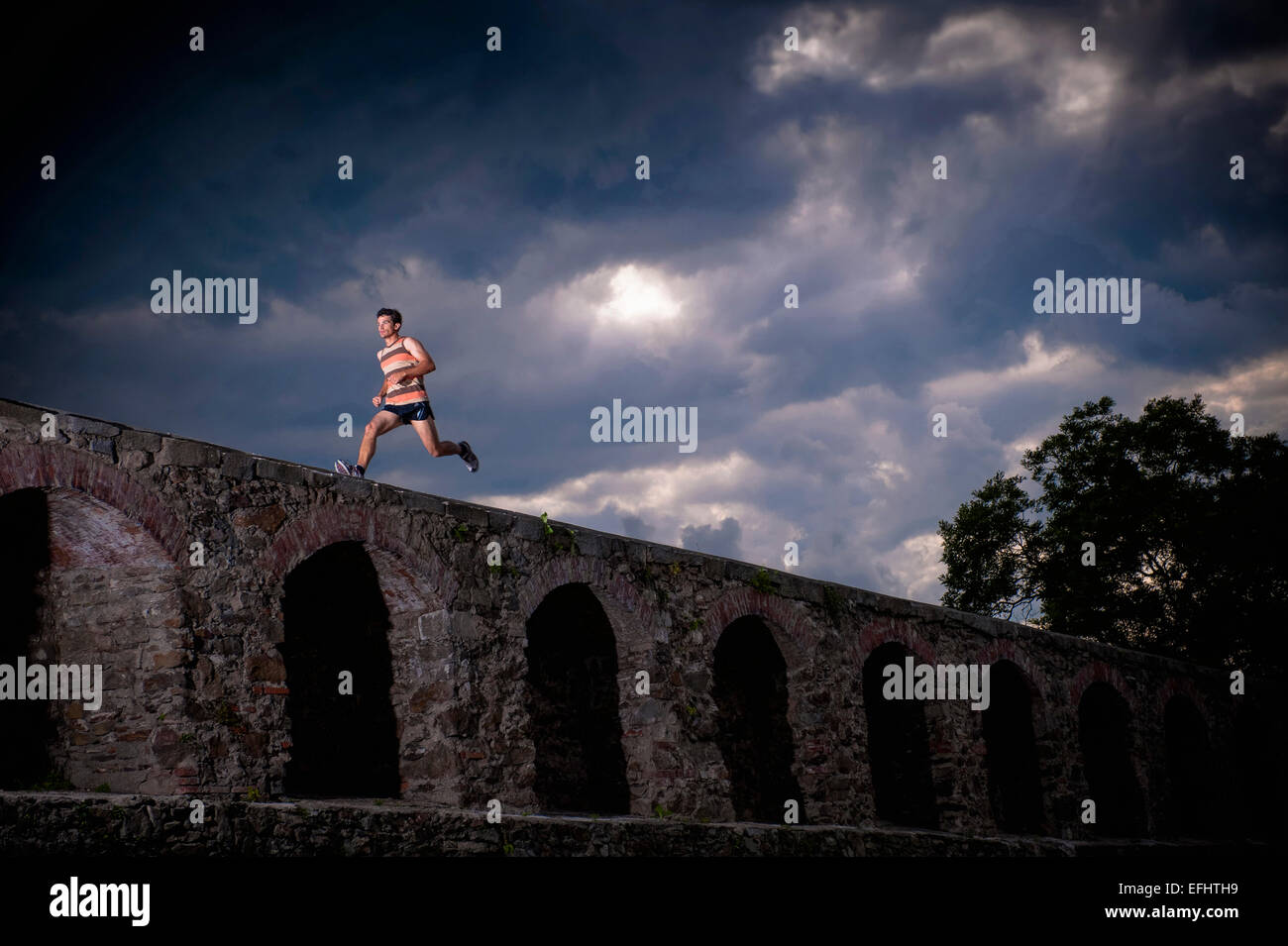 Uomo che corre lungo il muro di castello di Linz, Austria superiore, Austria Foto Stock