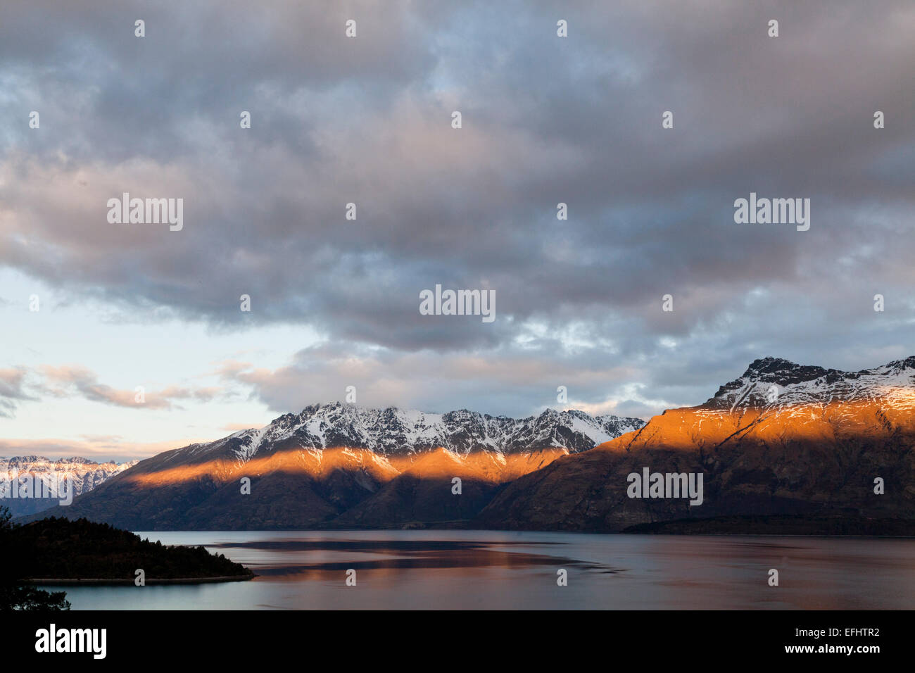 Raggio di luce dal sole al tramonto sulle montagne di Thomson, sul lago Wakatipu, Queenstown, Isola del Sud, Nuova Zelanda Foto Stock
