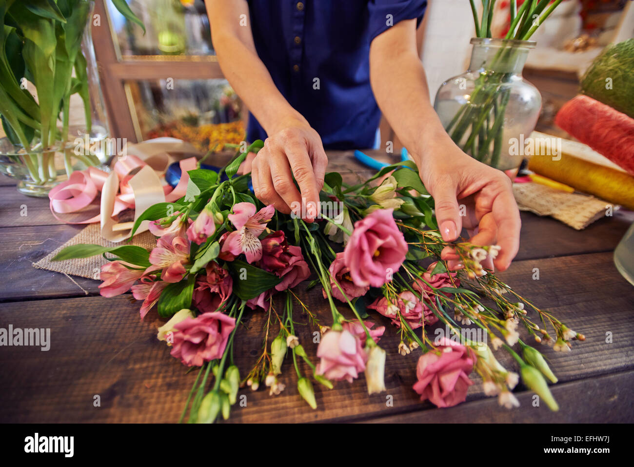 Fiorista femmina lavora con fiori in officina Foto Stock