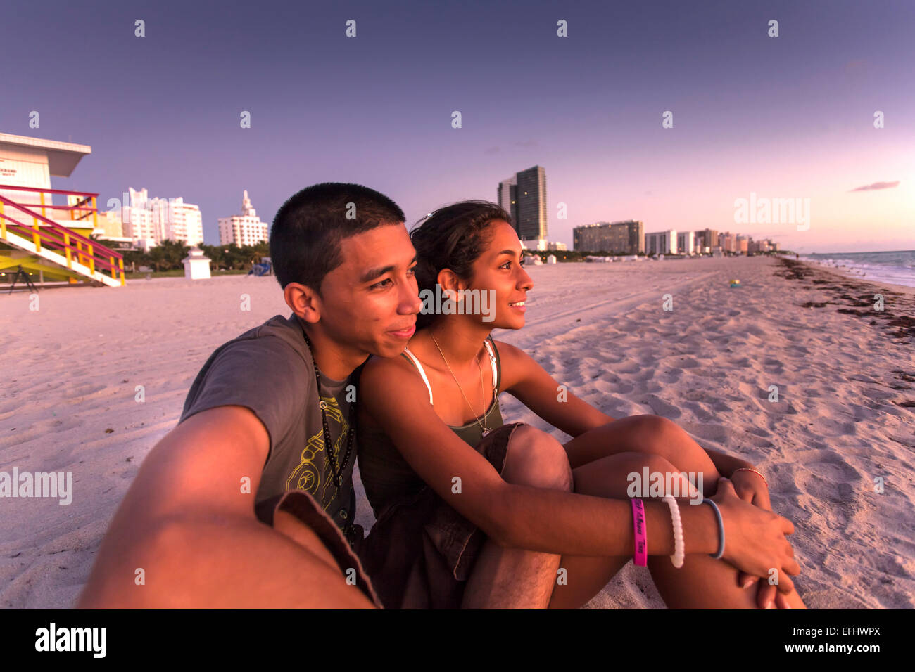 Giovani latino giovane osservare il tramonto sulla spiaggia, South Beach, Miami, Florida, Stati Uniti d'America Foto Stock